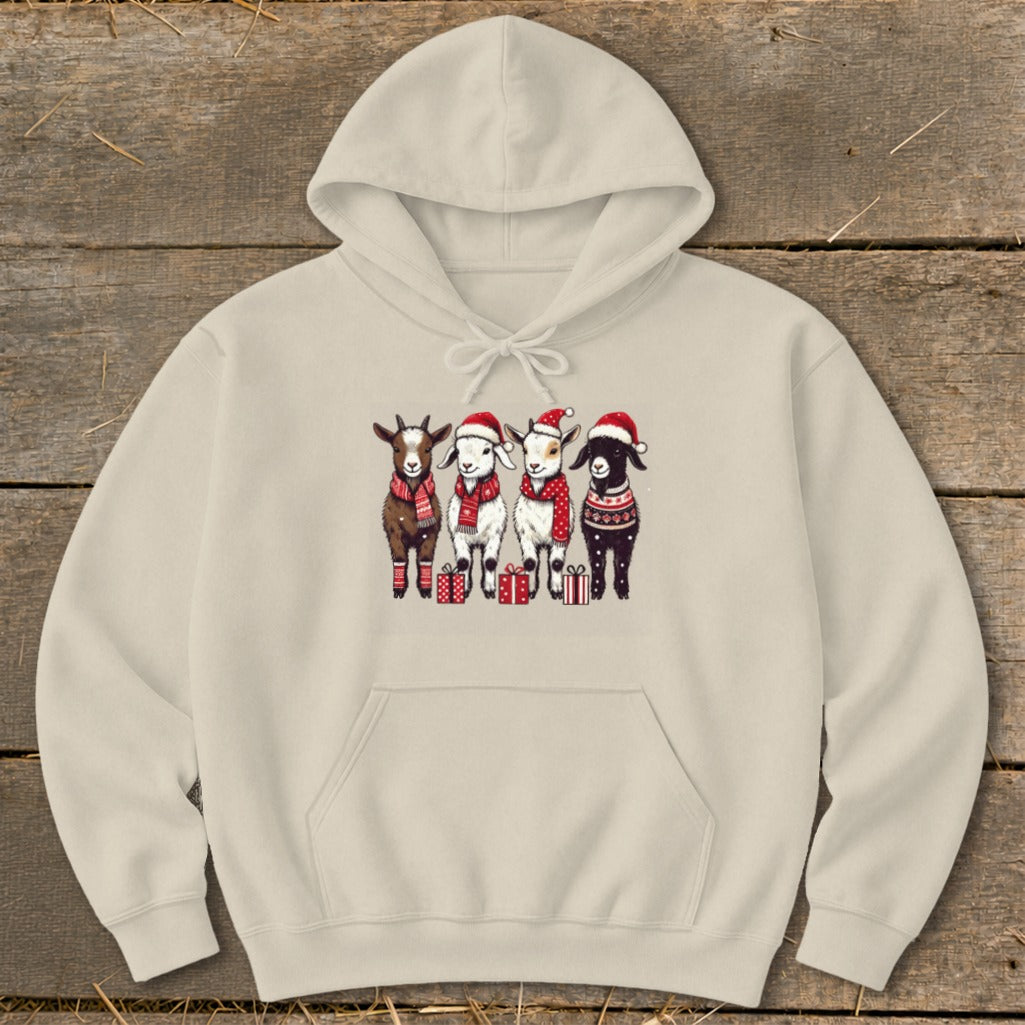 Four goats wearing Santa hats and scarves stand with presents on a cream hoodie.