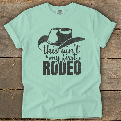 Light blue t-shirt with cowboy hat graphic and text "this ain't my first RODEO".