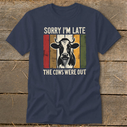 Navy t-shirt with a cow graphic and text "SORRY I'M LATE THE COWS WERE OUT".