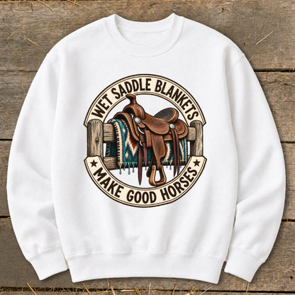 Western saddle on a fence with "Wet Saddle Blankets Make Good Horses" text.
