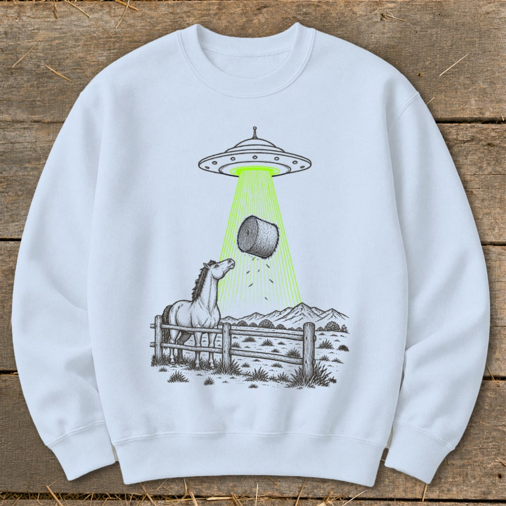 UFO beaming a hay bale onto a horse in a rural landscape.