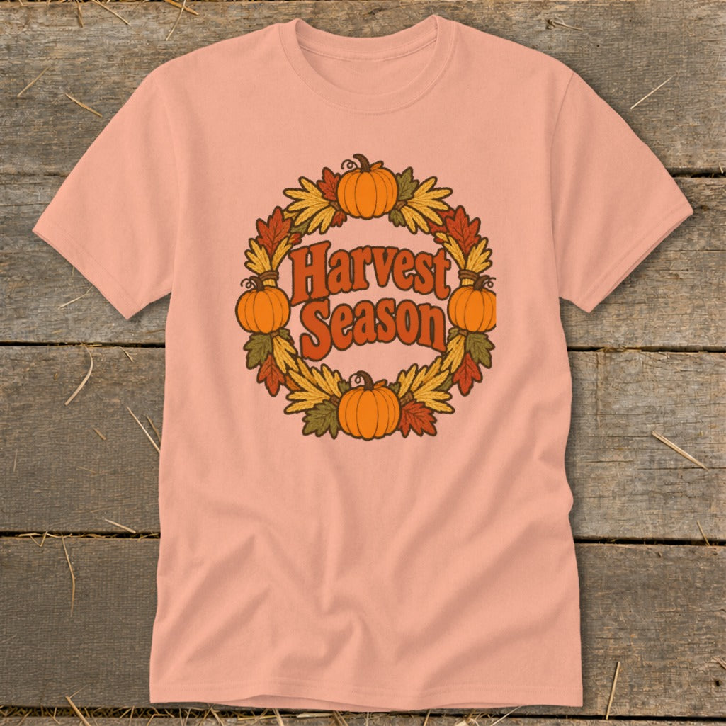 Peach t-shirt with retro "Harvest Season" text surrounded by pumpkins and autumn leaves.