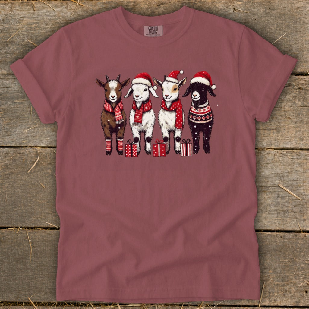 Four goats in Christmas hats and scarves stand with gifts.