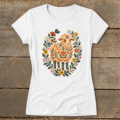 White t-shirt with a colorful sheep illustration surrounded by a floral wreath.