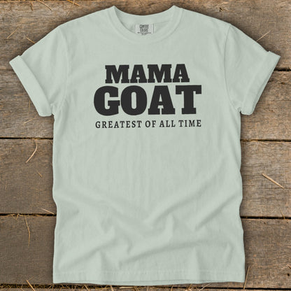 Light blue t-shirt with black text "MAMA GOAT GREATEST OF ALL TIME".