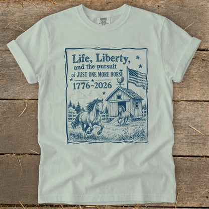 T-shirt with "Life, Liberty, and the pursuit of JUST ONE MORE HORSE" text and horse barn graphic.