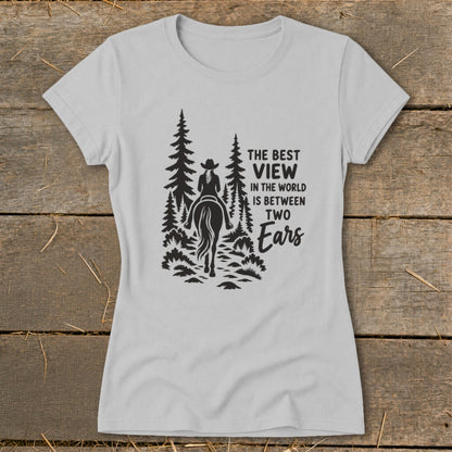 Light gray women's t-shirt featuring a black silhouette graphic of a horseback rider and pine trees with text.