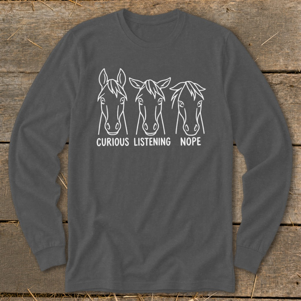Charcoal grey long-sleeve t-shirt with a white graphic of three horse heads and the text CURIOUS LISTENING NOPE.
