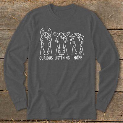 Charcoal grey long-sleeve t-shirt with a white graphic of three horse heads and the text CURIOUS LISTENING NOPE.