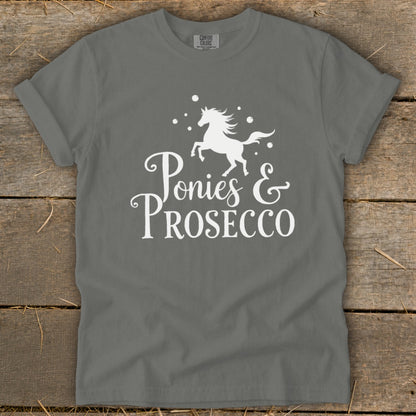 Grey t-shirt with white text and a graphic of a pony and bubbles reading "Ponies & Prosecco".