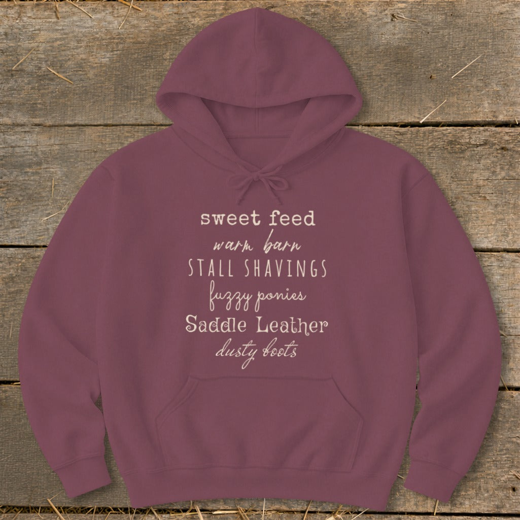 Burgundy hoodie with text "sweet feed warm barn stall shavings fuzzy ponies saddle leather dusty boots".