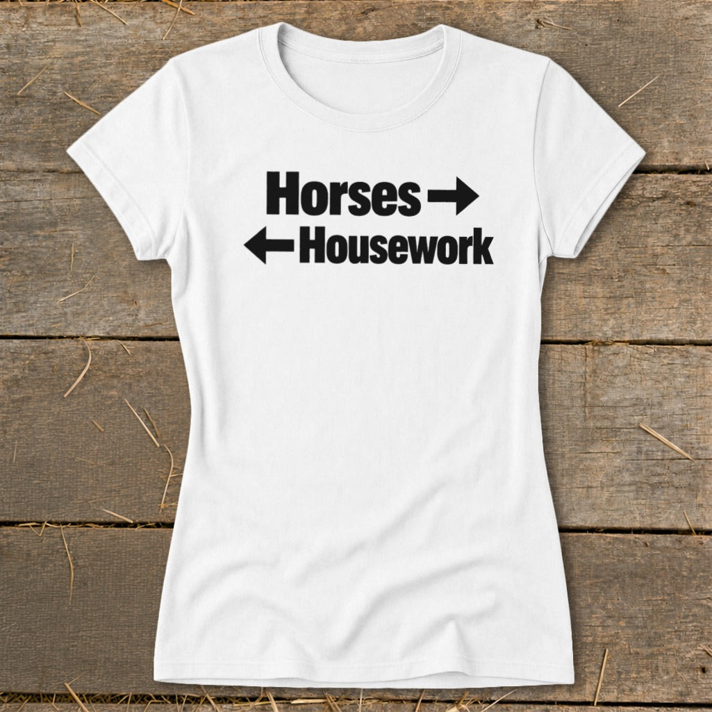 A white t-shirt with black text that reads "Horses" with a right arrow and "Housework" with a left arrow.