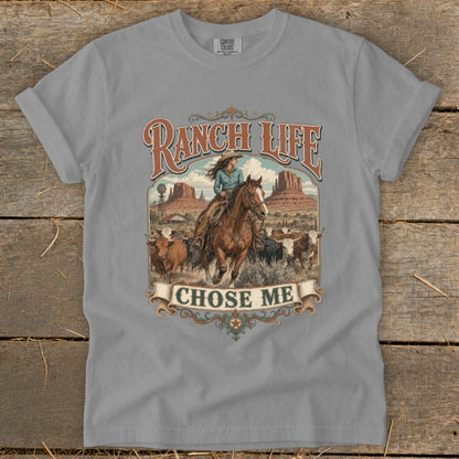 Ranch Life Chose Me graphic on light gray t-shirt featuring a cowgirl on horseback herding cattle.