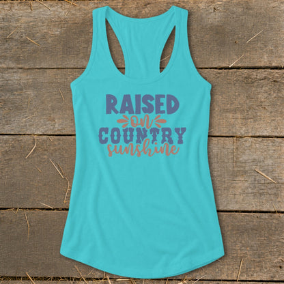 Turquoise tank top with "Raised on Country Sunshine" text in purple and orange.
