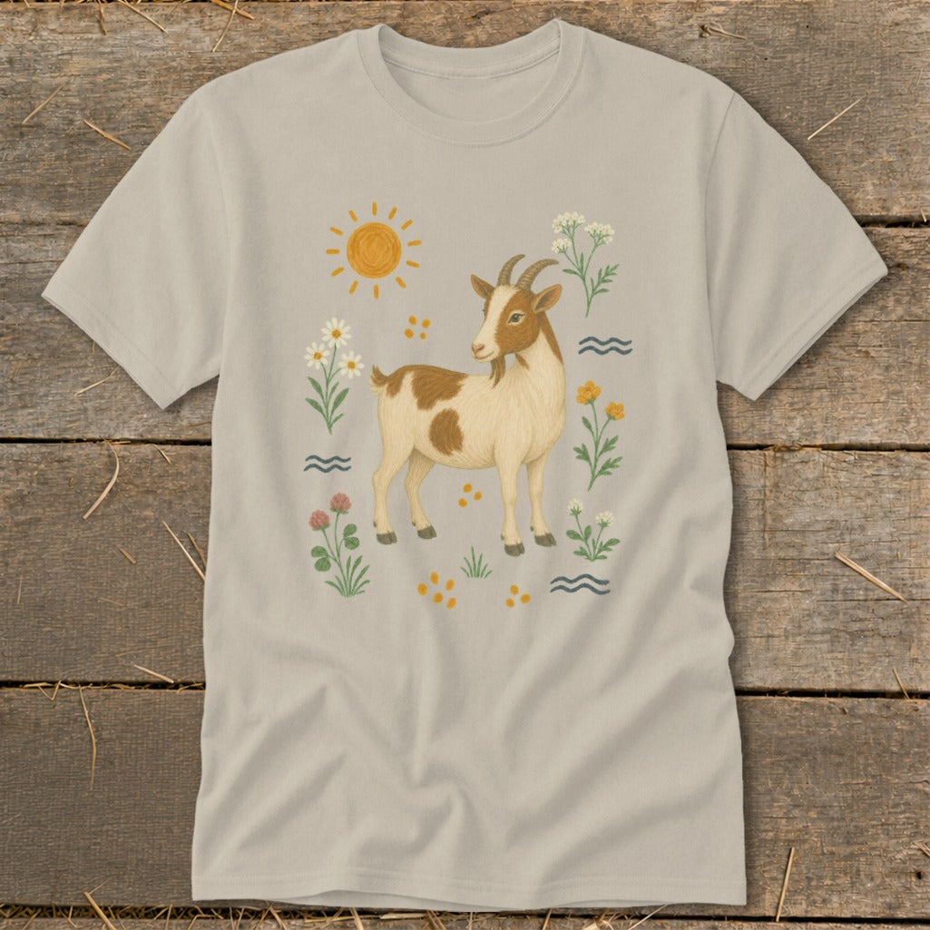 T-shirt with a drawing of a brown and white goat surrounded by flowers and a sun.