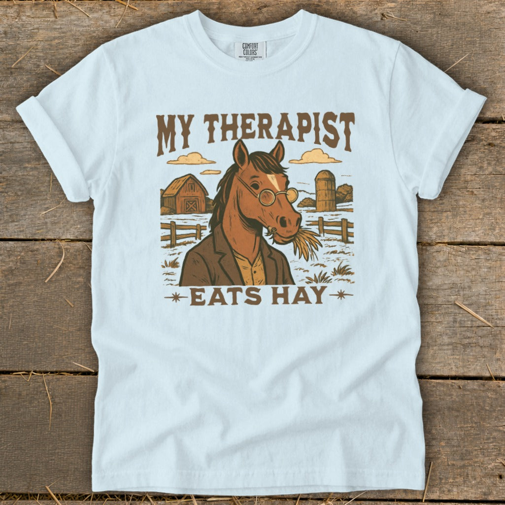 Light blue t-shirt with horse graphic and text "MY THERAPIST EATS HAY".