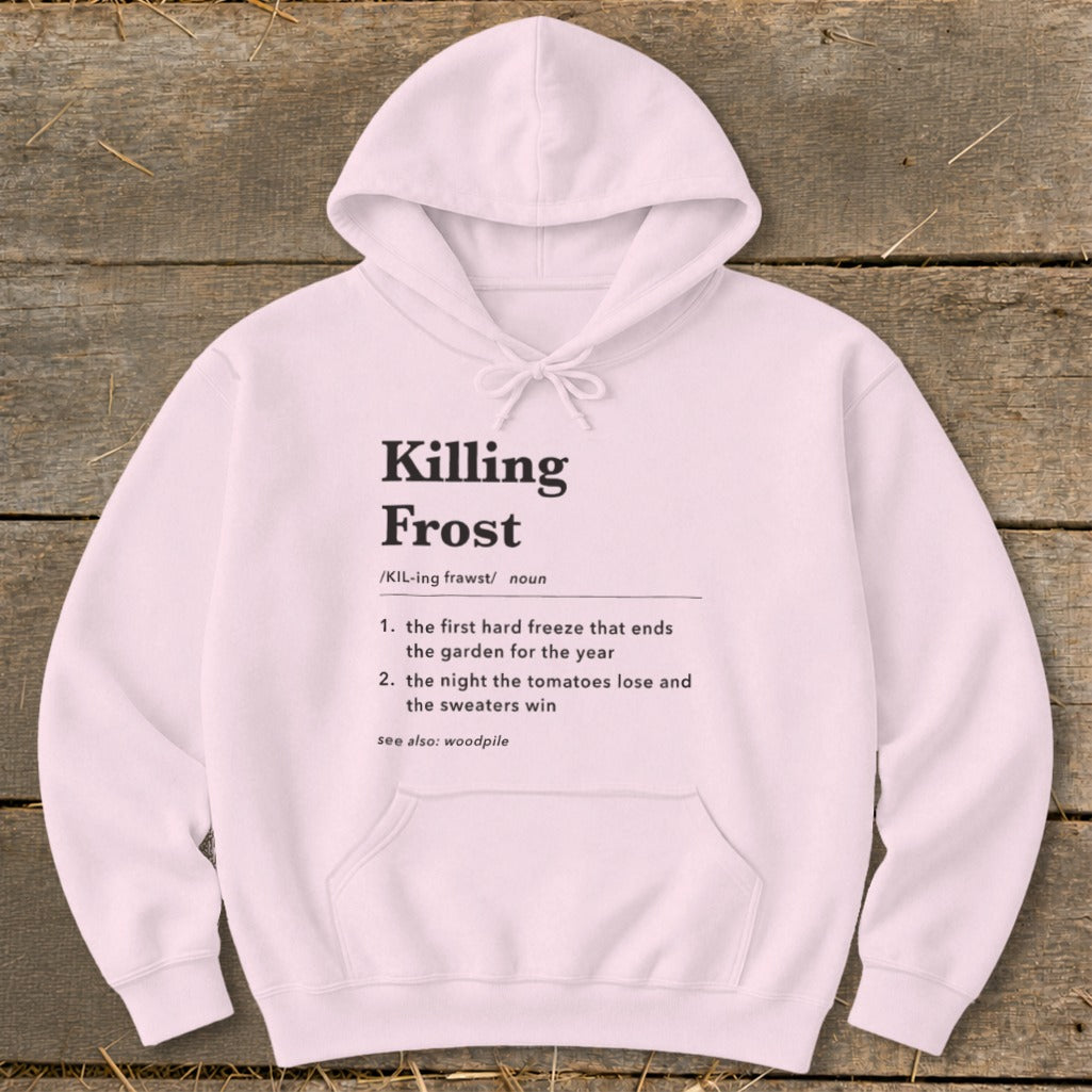 Light pink hooded sweatshirt featuring black dictionary-style text defining Killing Frost on a rustic wooden background.