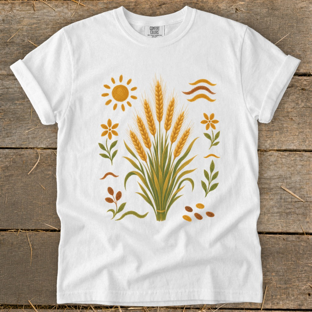White t-shirt with a central graphic of wheat stalks, sun, flowers, and seeds.