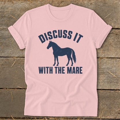 Pink t-shirt with dark blue text "DISCUSS IT" above a horse silhouette and "WITH THE MARE" below.