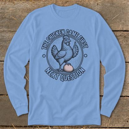 Light blue long sleeve shirt with a chicken and egg graphic saying "The chicken came first. Next question."