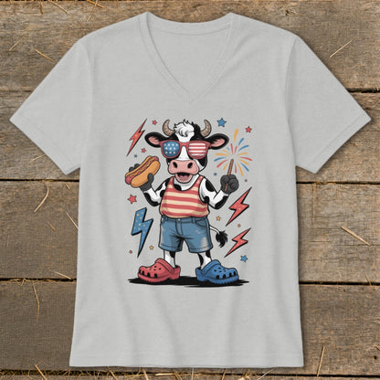 Cartoon cow in patriotic attire holding a hot dog and sparkler.
