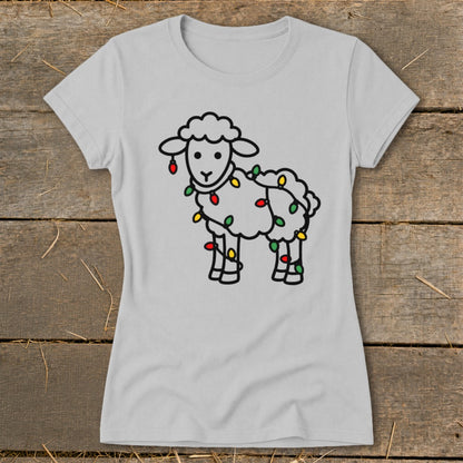 A light gray t-shirt featuring a black outline graphic of a sheep tangled in colorful Christmas lights.