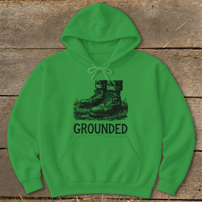 Green hoodie with a graphic of boots on grass and the word "GROUNDED".