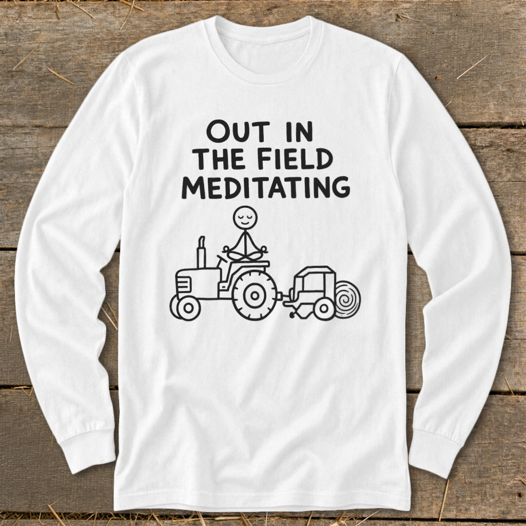 White long-sleeve shirt with text and a drawing of a stick figure meditating on a tractor.