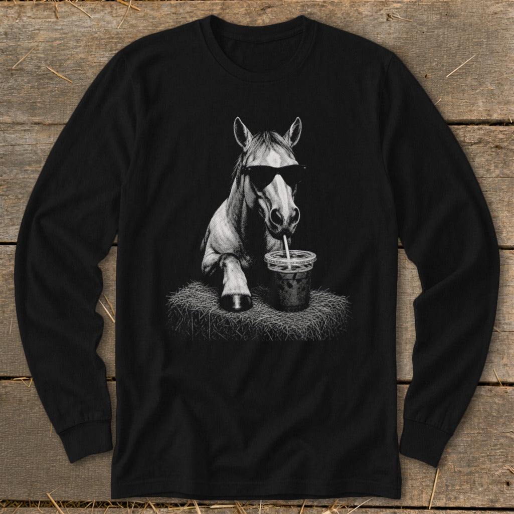 Horse wearing sunglasses drinks from a straw on a hay bale.