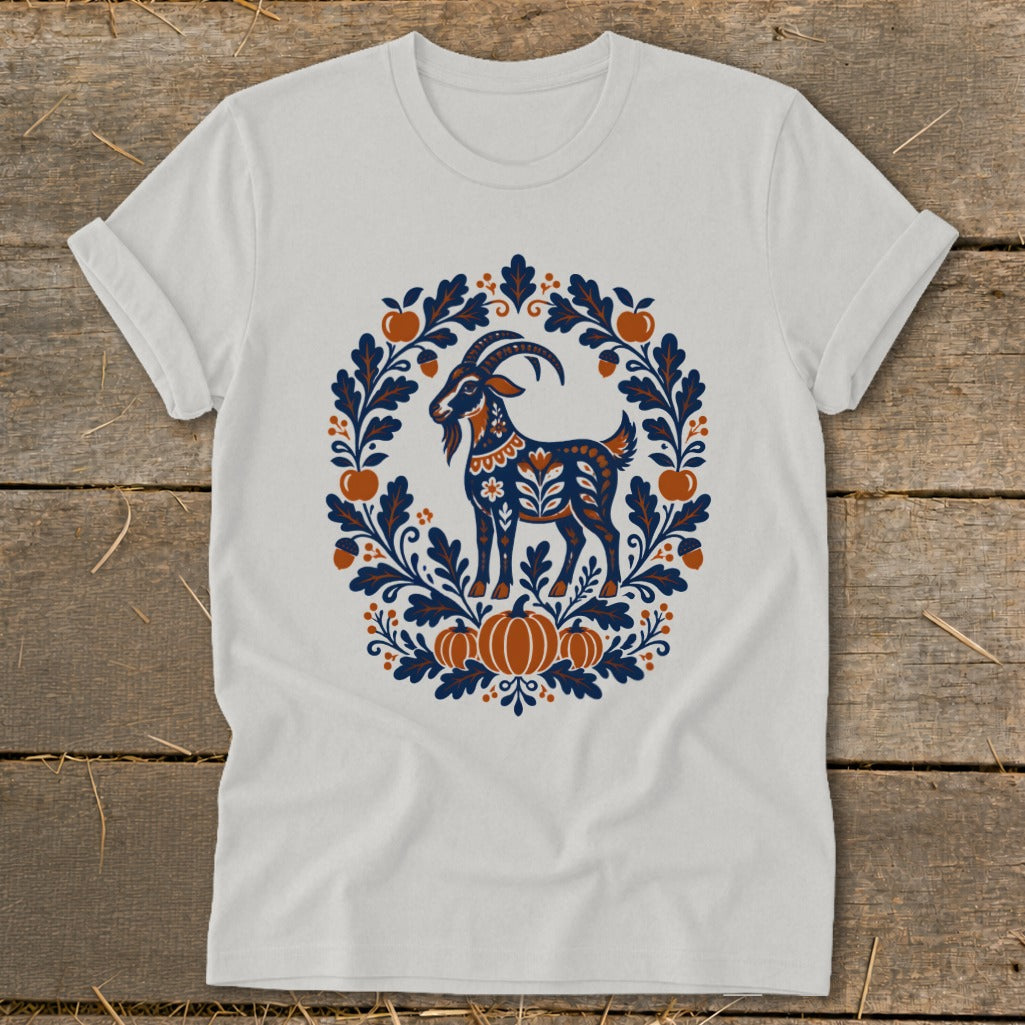 Light gray t-shirt with a folk-art graphic of a goat framed by autumn leaves, pumpkins, and acorns.