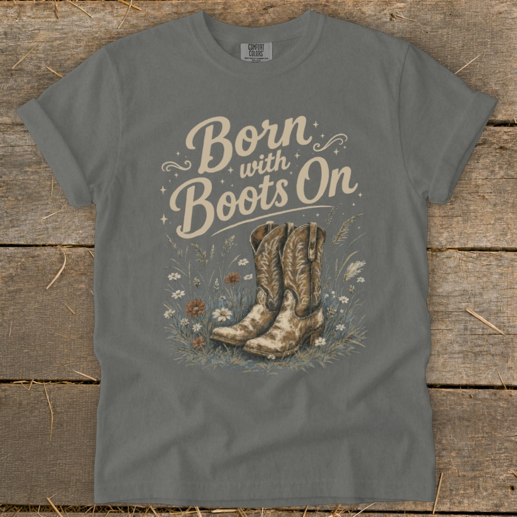 Gray t-shirt with "Born with Boots On" text and cowboy boots in wildflowers graphic.