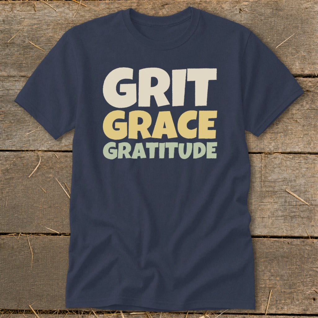 Dark blue short-sleeve t-shirt with the words "GRIT GRACE GRATITUDE" printed in stacked, block letters across the chest.