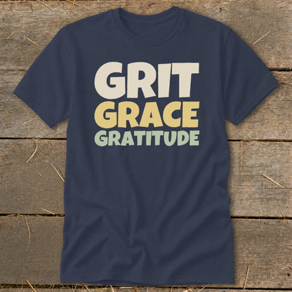 Dark blue short-sleeve t-shirt with the words "GRIT GRACE GRATITUDE" printed in stacked, block letters across the chest.