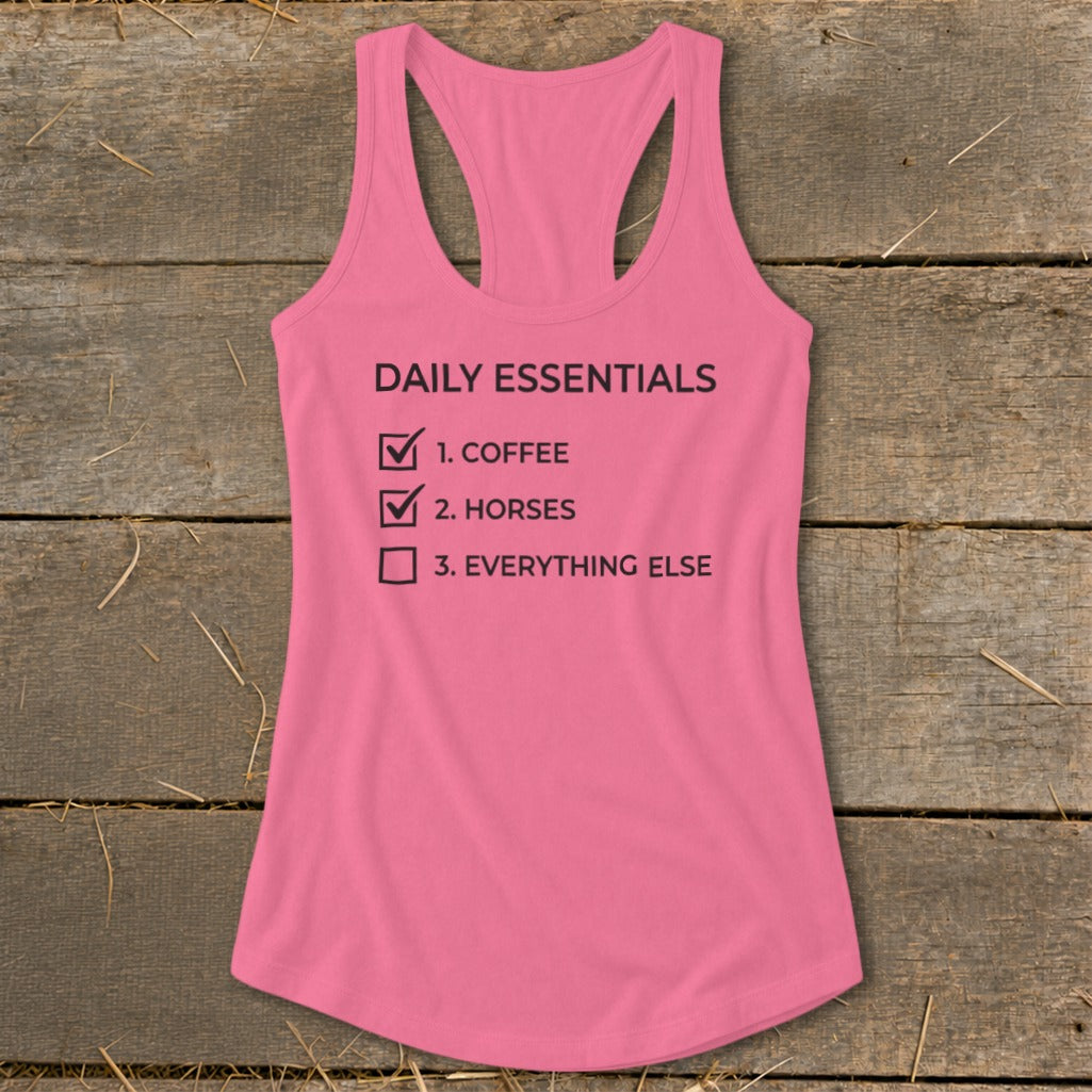 Pink tank top with "Daily Essentials" checklist: coffee, horses, everything else.
