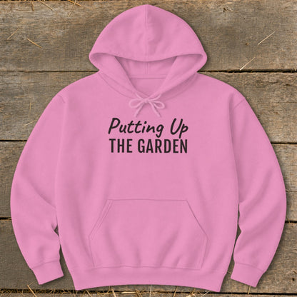 Pink hoodie with "Putting Up THE GARDEN" text on the chest.