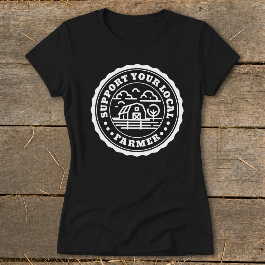 Black t-shirt with circular emblem featuring barn, trees, and text "Support Your Local Farmer".