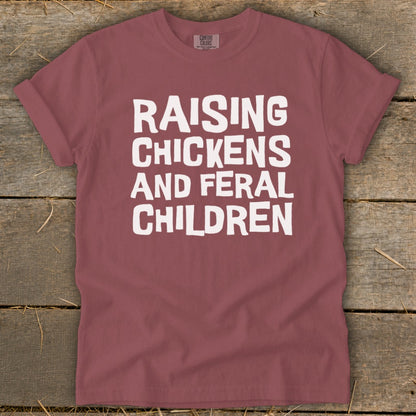 Maroon t-shirt with white text that reads "Raising Chickens and Feral Children."