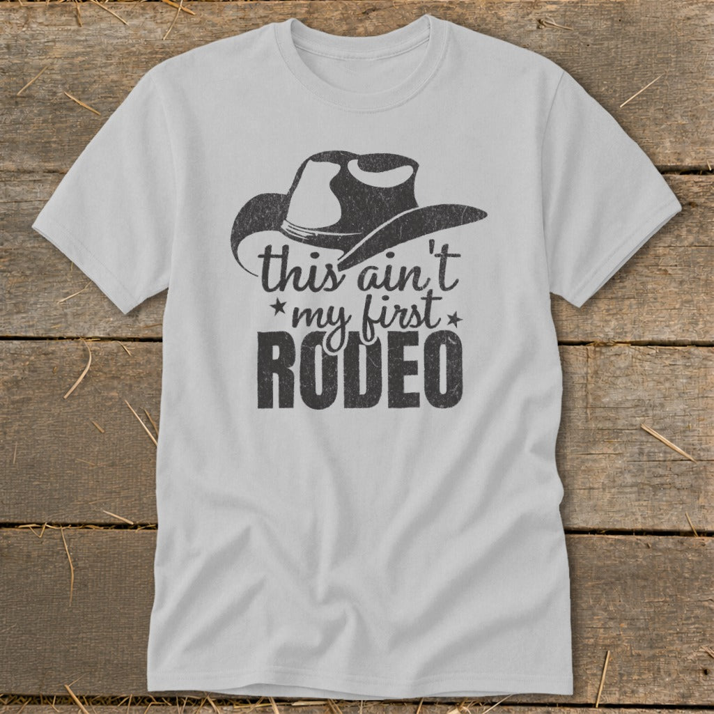 Light gray t-shirt with a cowboy hat graphic and the text "this ain't my first RODEO".