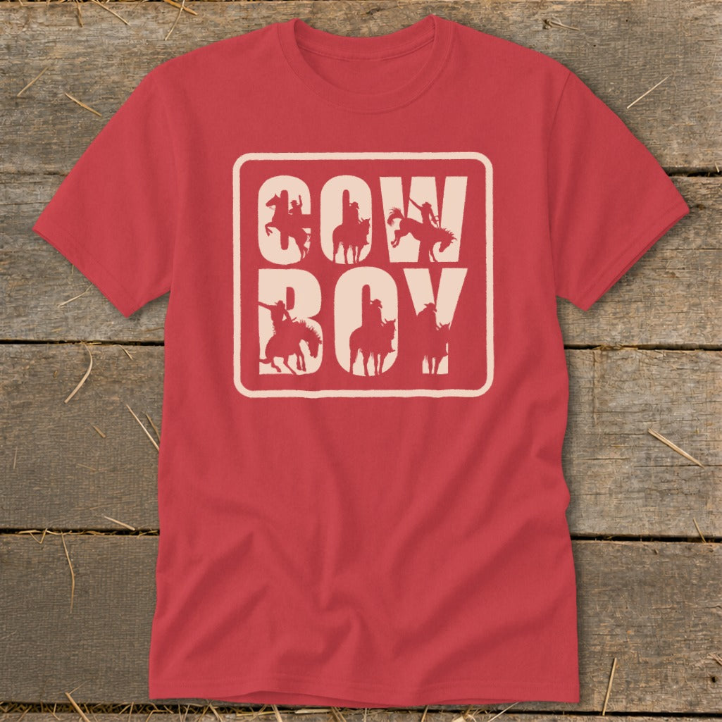 Red t-shirt with cream "COW BOY" text and cowboy silhouettes inside white box.