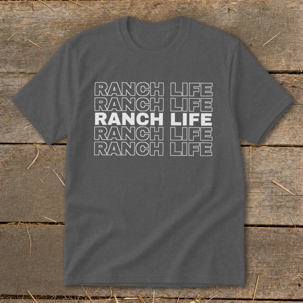 Charcoal gray t-shirt featuring the stacked white text "RANCH LIFE" on a wooden background.