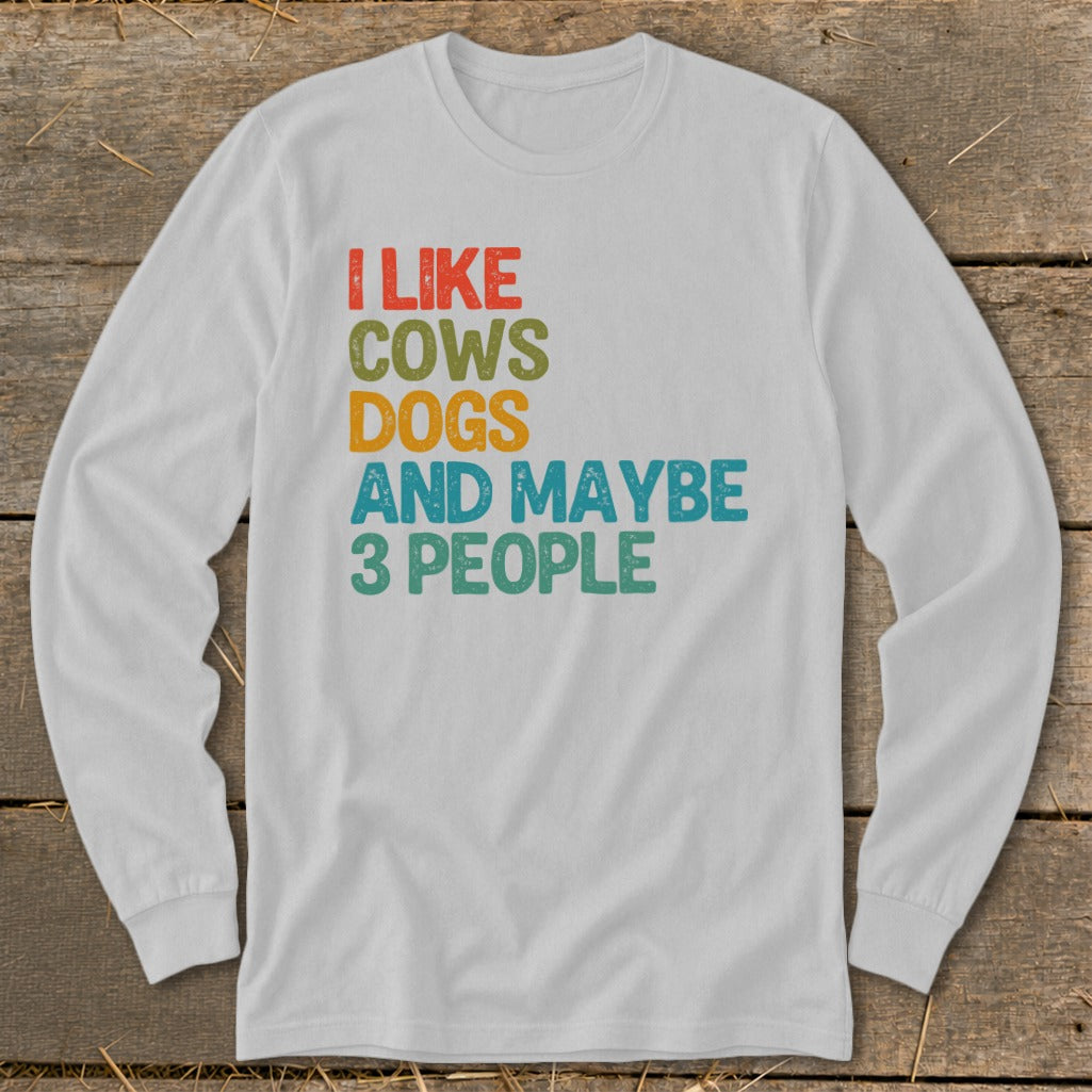 White long-sleeve shirt with text "I LIKE COWS DOGS AND MAYBE 3 PEOPLE".