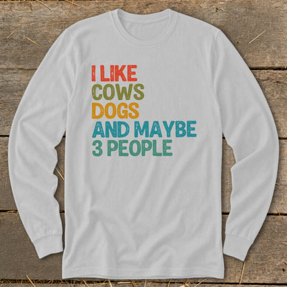 White long-sleeve shirt with text "I LIKE COWS DOGS AND MAYBE 3 PEOPLE".