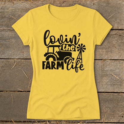 Yellow t-shirt with black "lovin' the farm life" text, tractor, and windmill graphic.