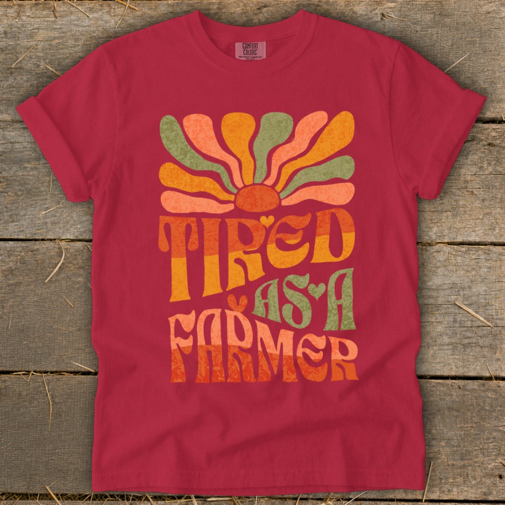 Crimson t-shirt with "Tired As A Farmer" text and a retro sun graphic.