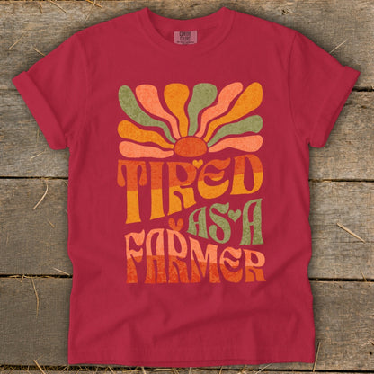 Crimson t-shirt with "Tired As A Farmer" text and a retro sun graphic.