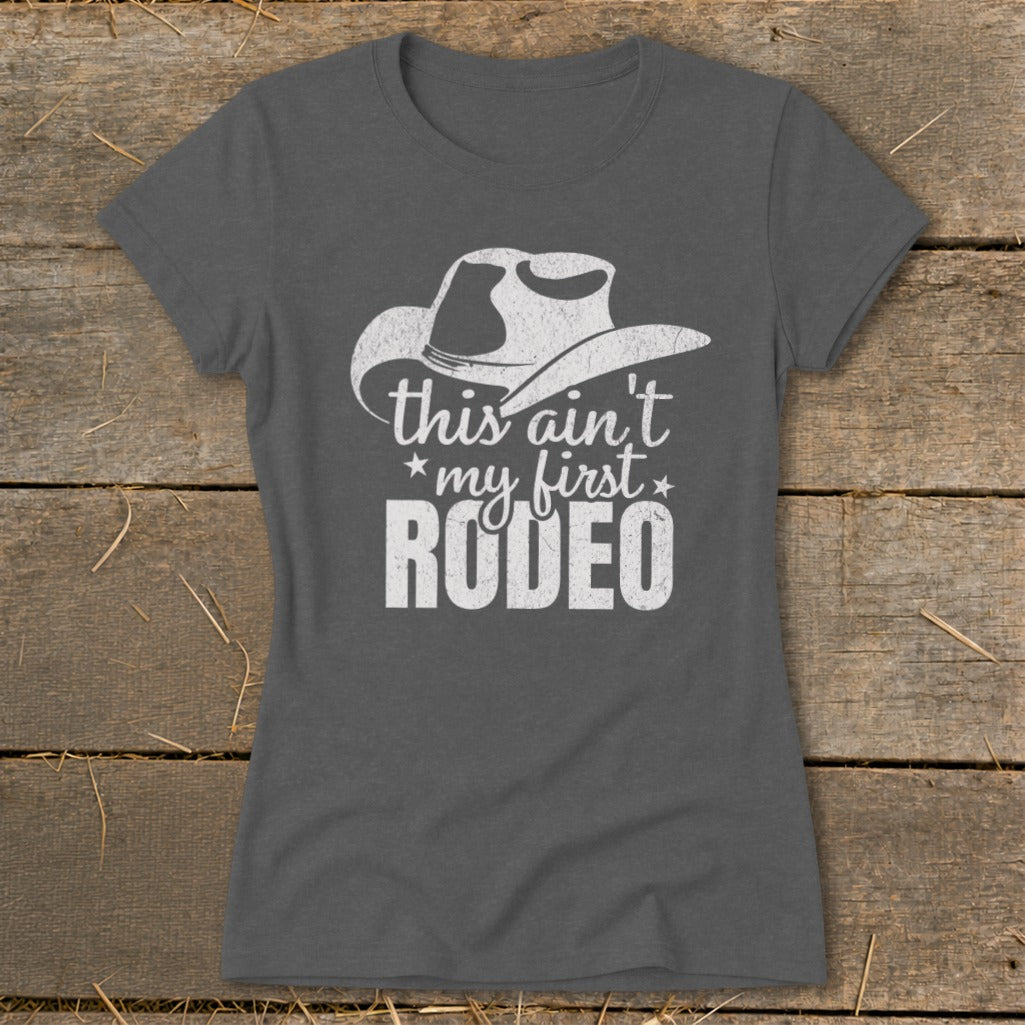 Gray t-shirt with white distressed graphic of a cowboy hat and text "this ain't my first RODEO".