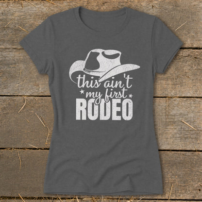 Gray t-shirt with white distressed graphic of a cowboy hat and text "this ain't my first RODEO".
