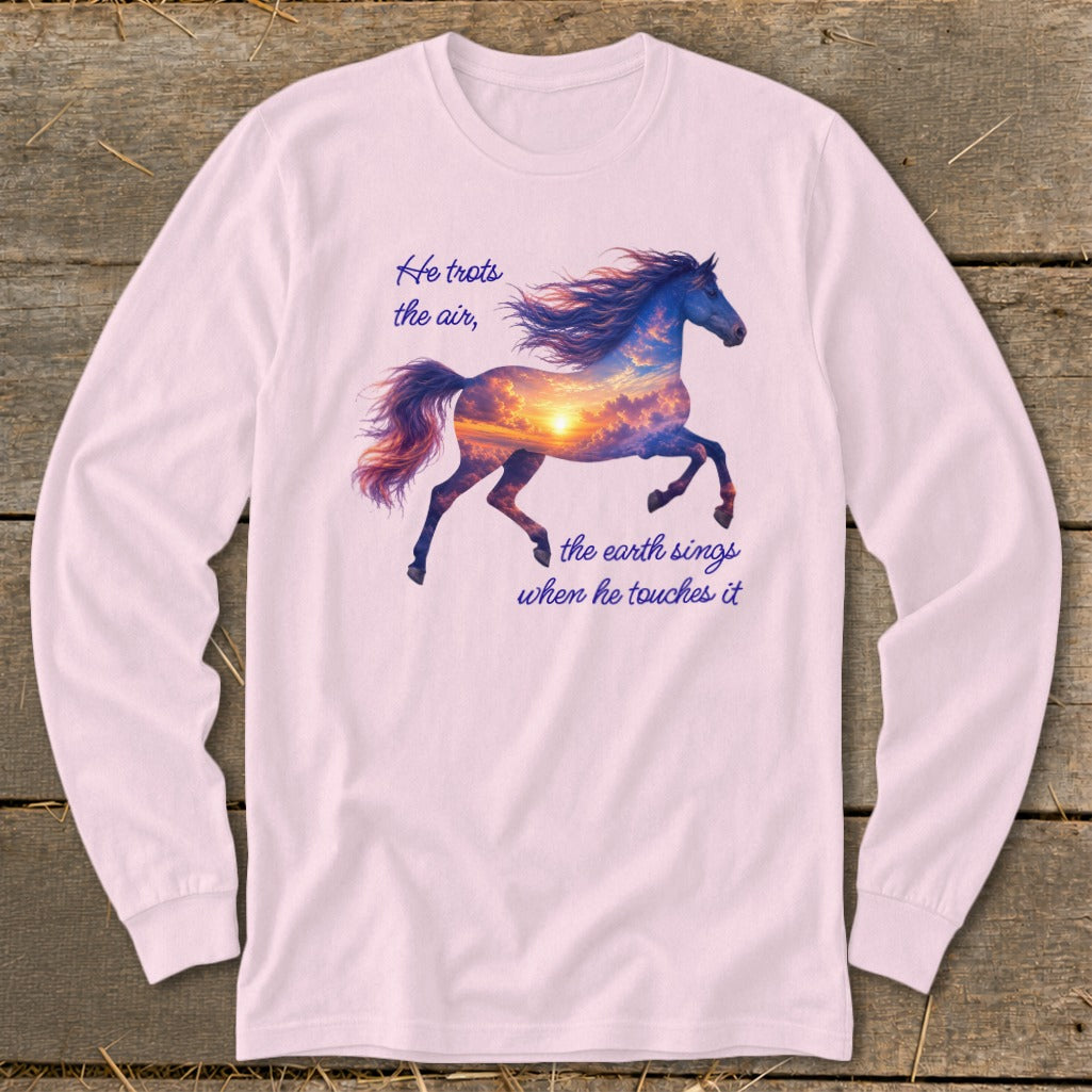 A light pink long-sleeve t-shirt featuring a horse graphic filled with a sunset sky and text reading He trots the air, the earth sings when he touches it.