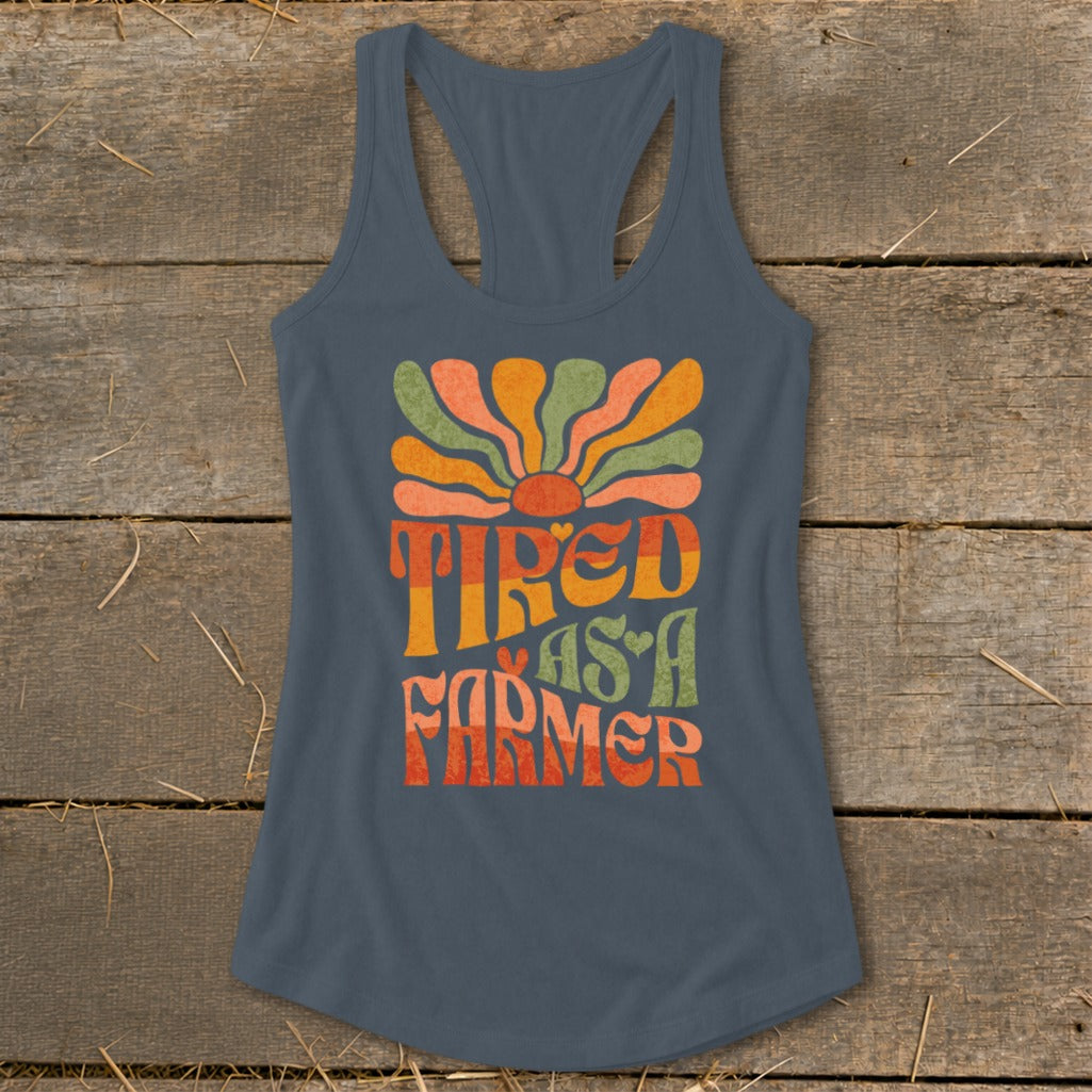 Grey tank top with "Tired As A Farmer" in colorful retro text and sun graphic.