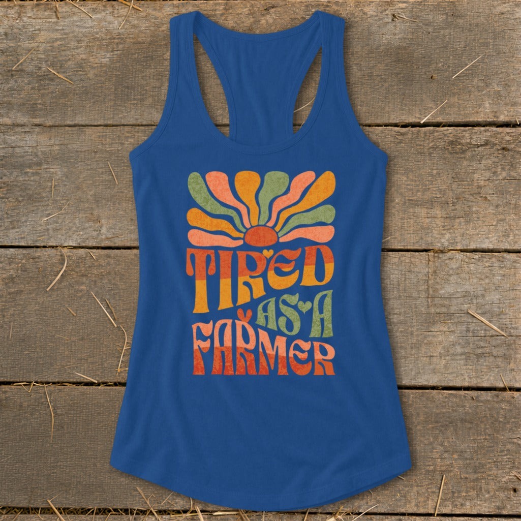 Blue racerback tank top with retro graphic: Tired As A Farmer.